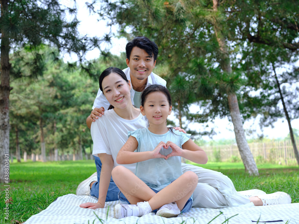 Happy family of three playing in the park