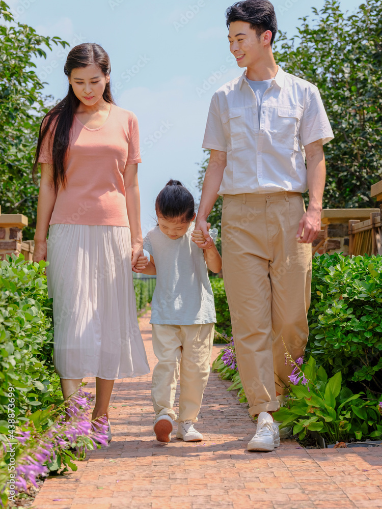 A happy family of three walking outdoors