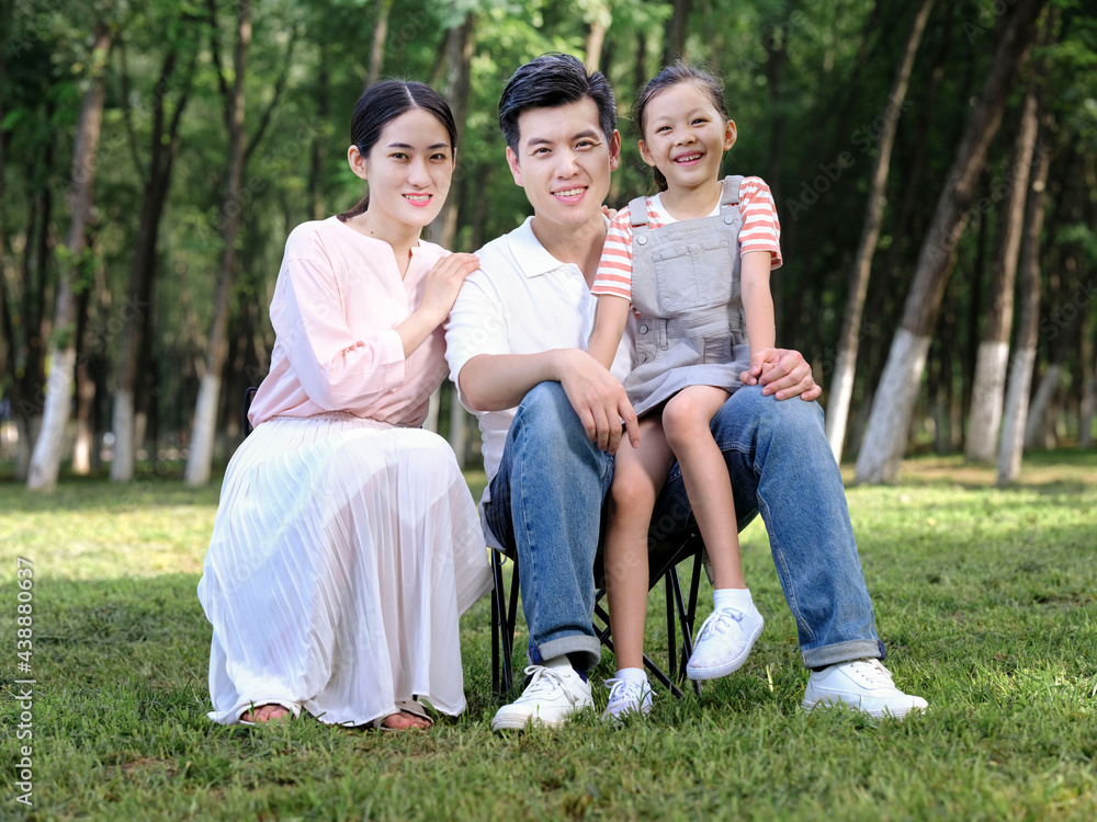 Happy family of three playing in the park