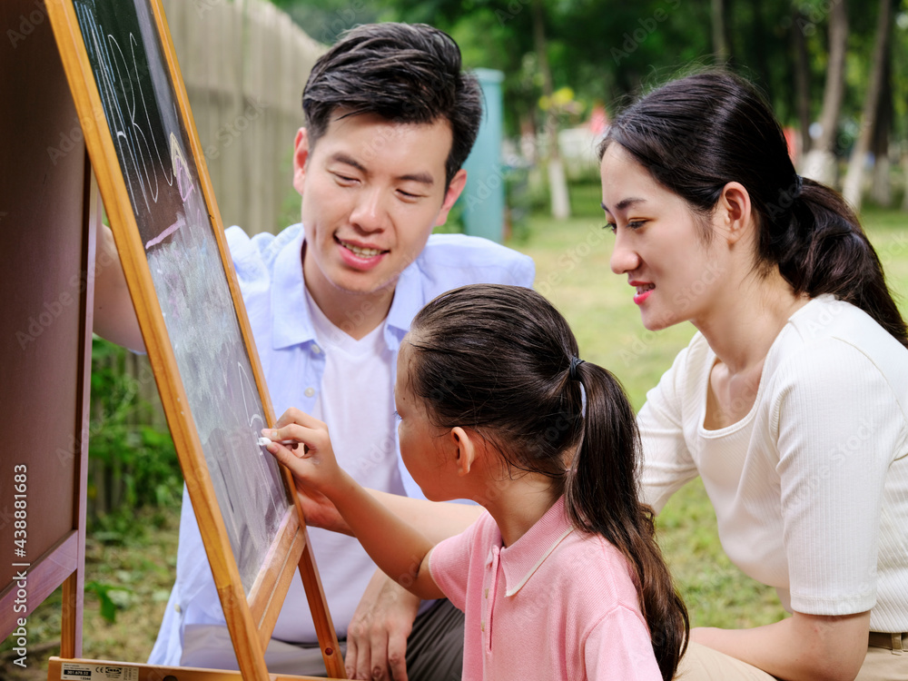 Happy family of three painting in the park