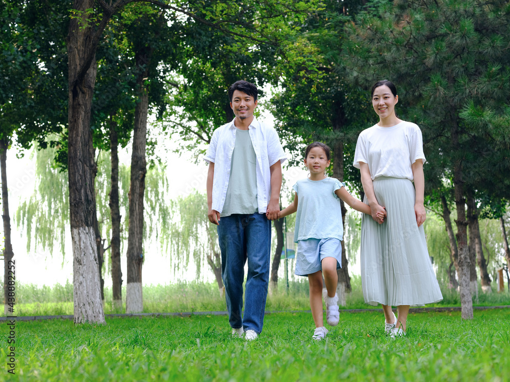 Happy family of three playing in the park