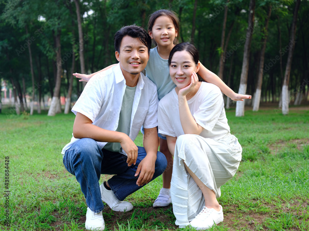 Happy family of three playing in the park