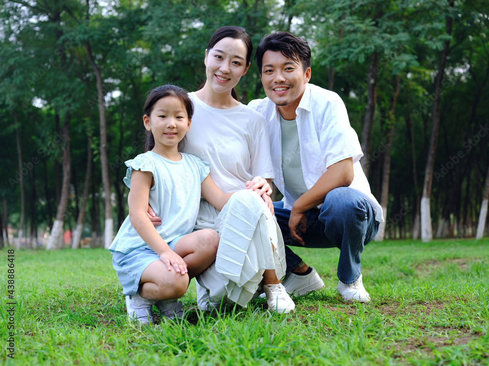 Happy family of three playing in the park