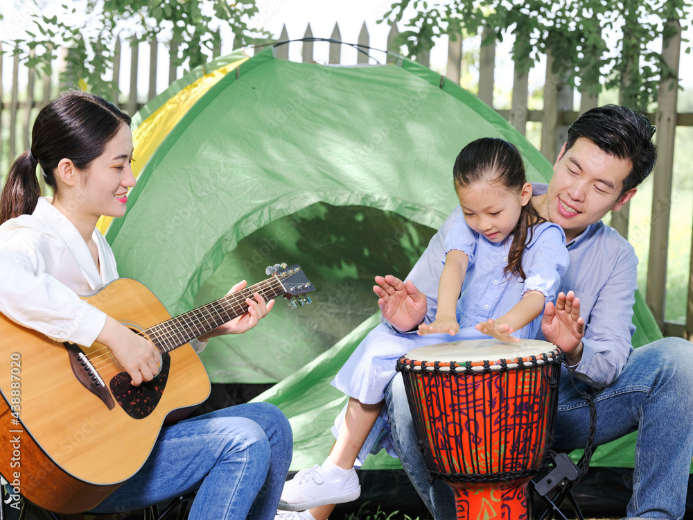 A Happy family of three camping outdoors