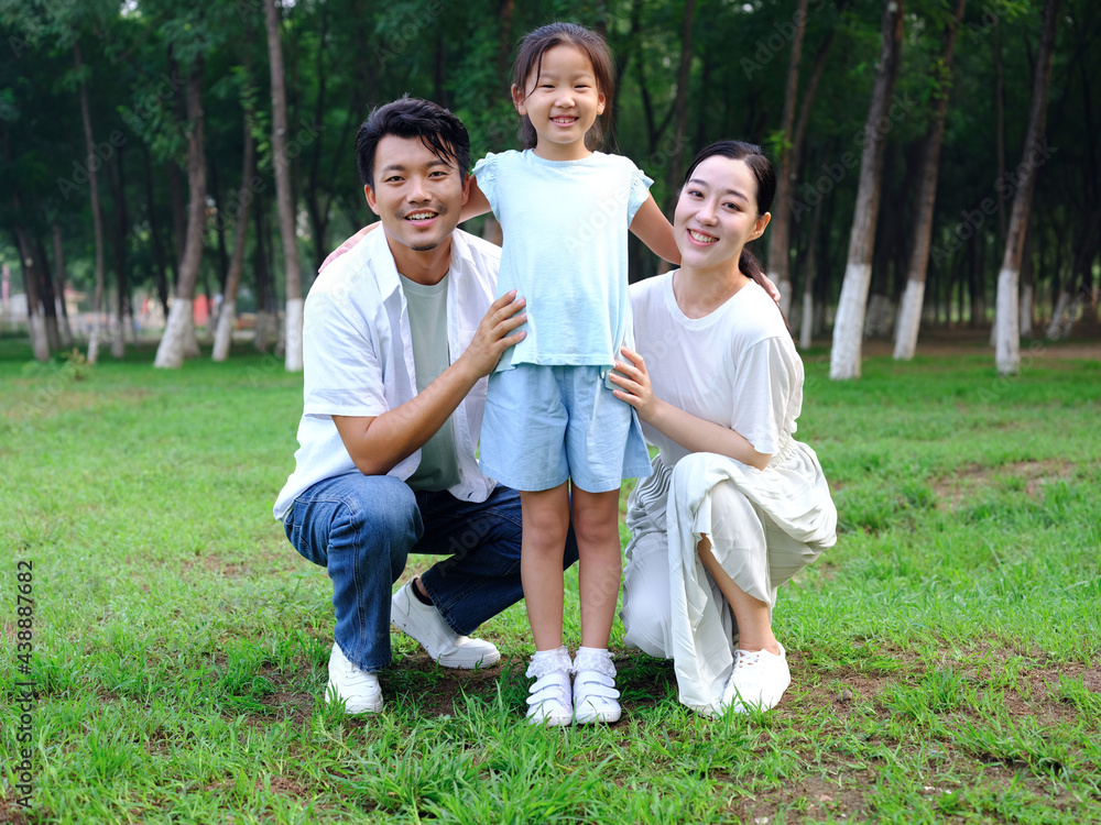 Happy family of three playing in the park