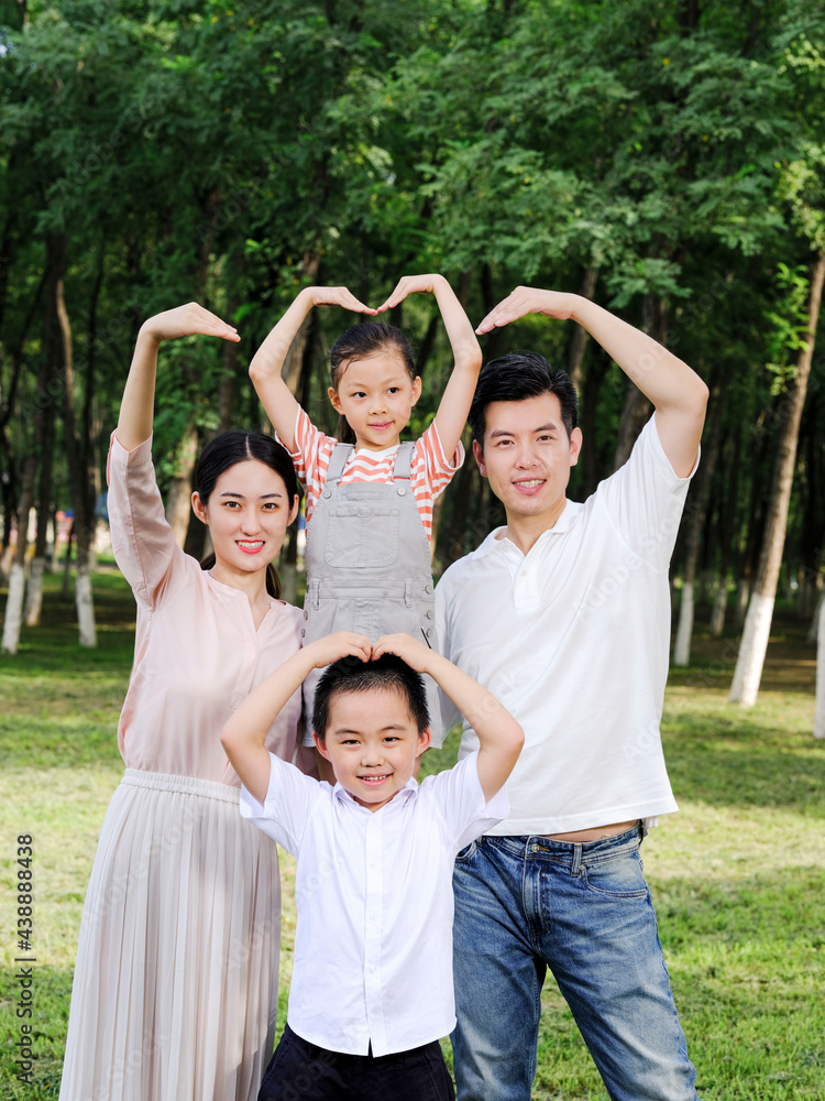 Happy family of four playing in the park