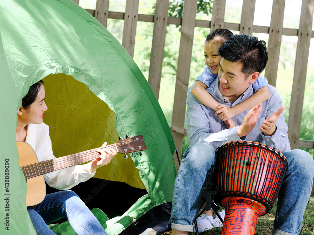 A Happy family of three camping outdoors