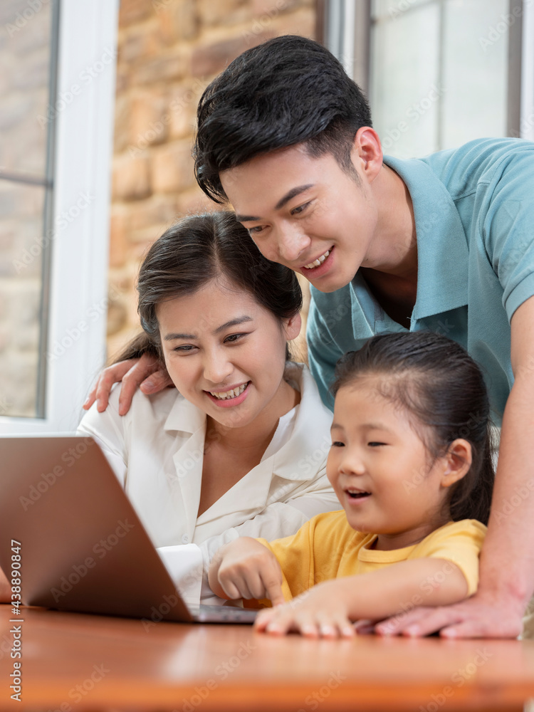 A Happy family of three using laptop