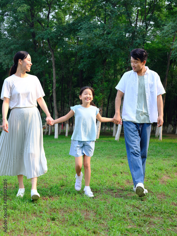 Happy family of three playing in the park