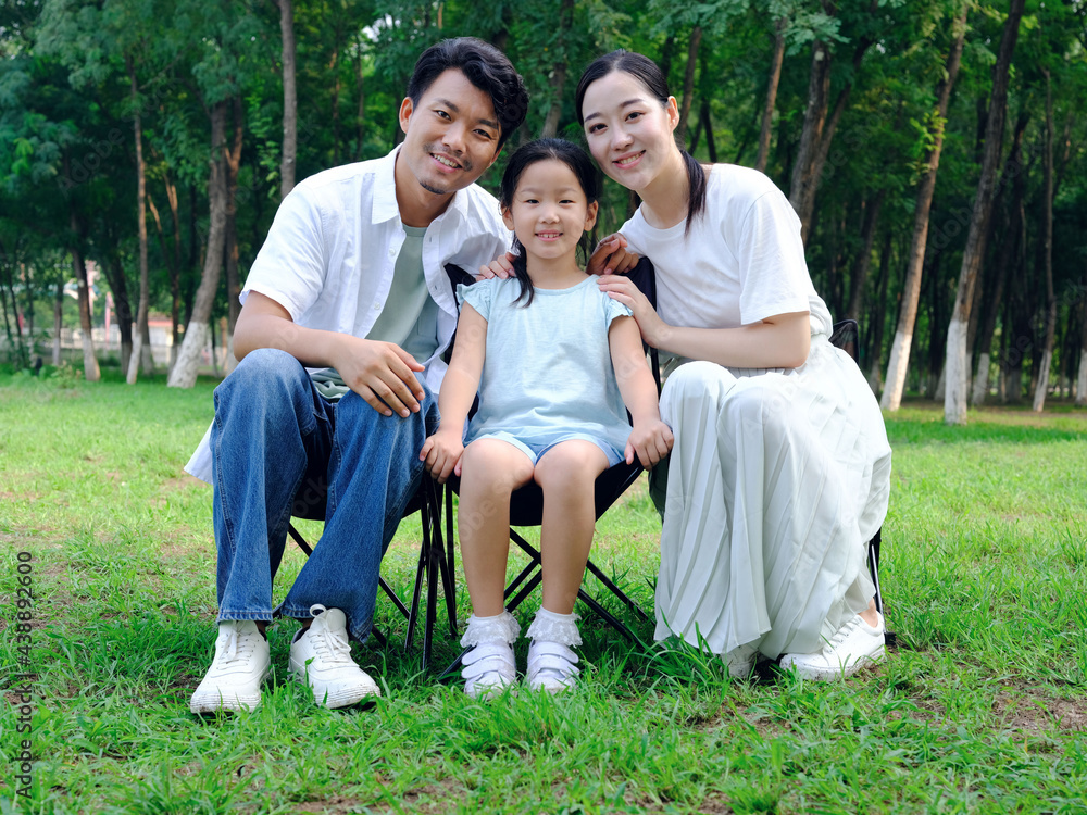 Happy family of three playing in the park