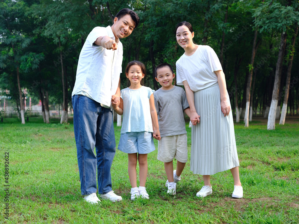 Happy family of four playing in the park