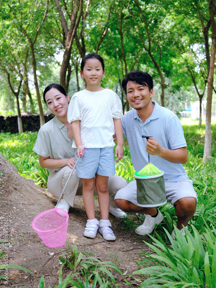 一个幸福的三口之家在户外捕捉昆虫