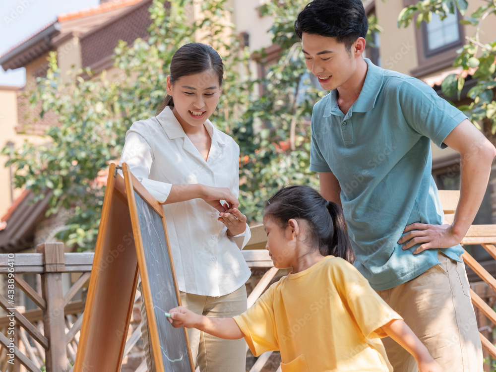 A Happy family of three painting outdoors