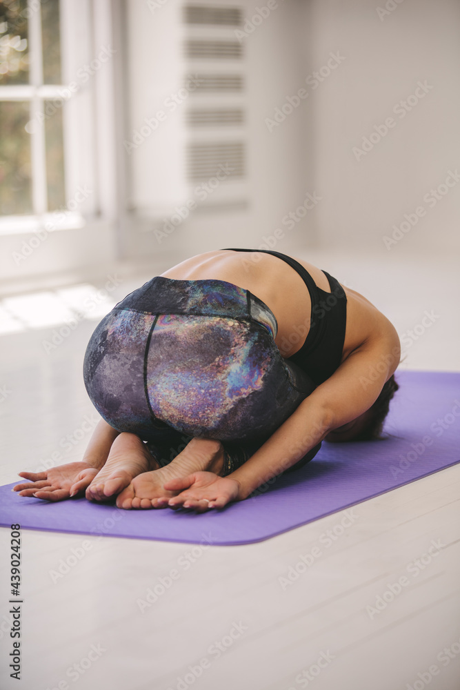 Woman doing yoga in fitness studio