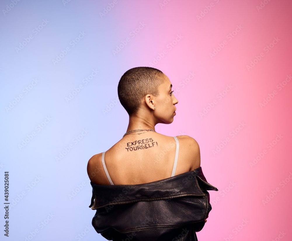 Shaved head woman with express yourself written on back