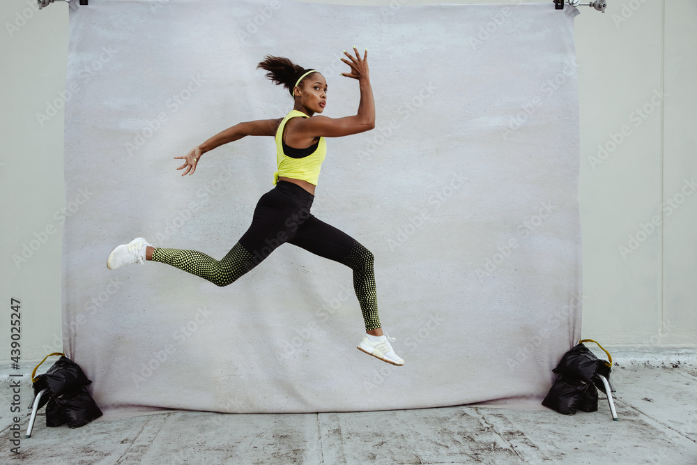 Female athlete in sportswear jumping midair