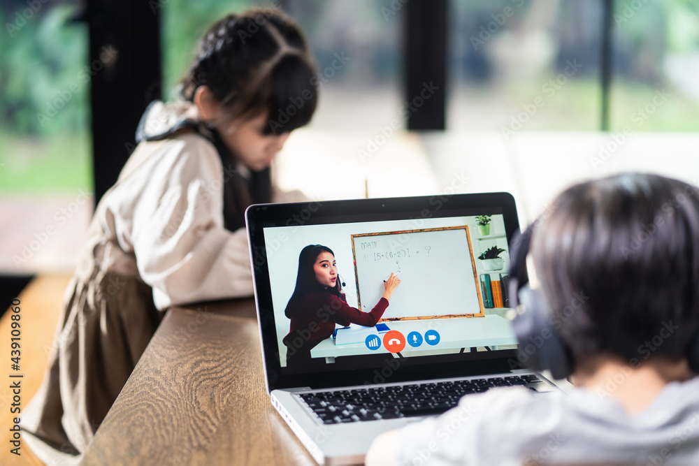 Asian homeschool boy and girl learning online at home by using tablet.	