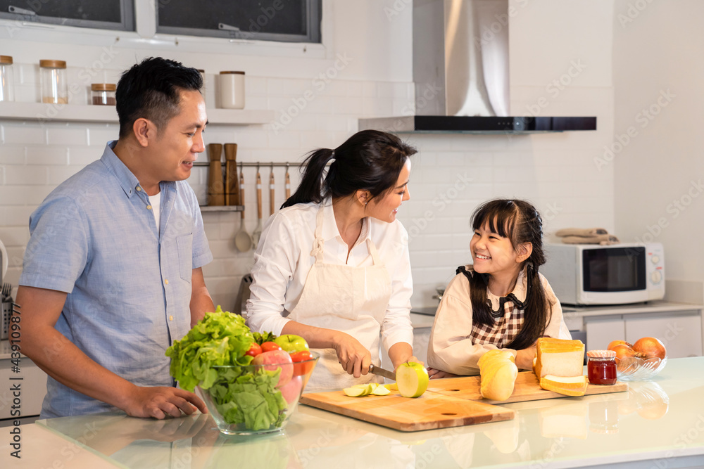 Asian happy family, parent cook food with daughter in kitchen at house