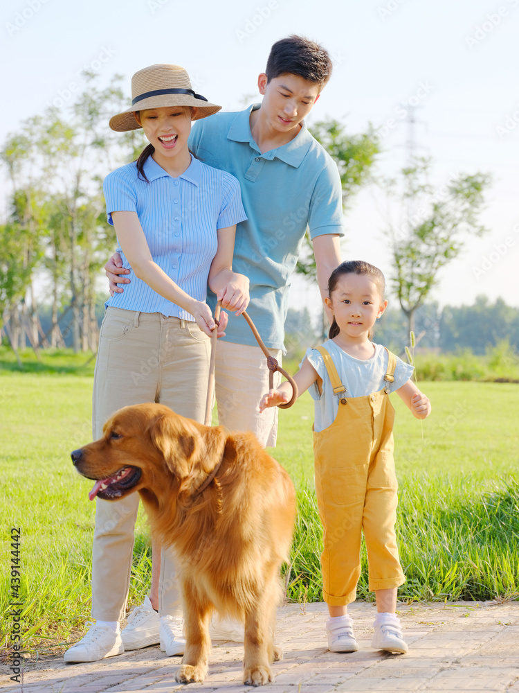 Happy family of three and pet dog in the park