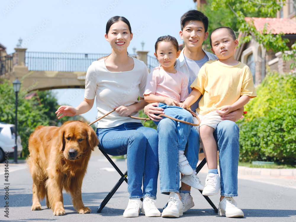 幸福的四口之家和户外照片中的宠物狗