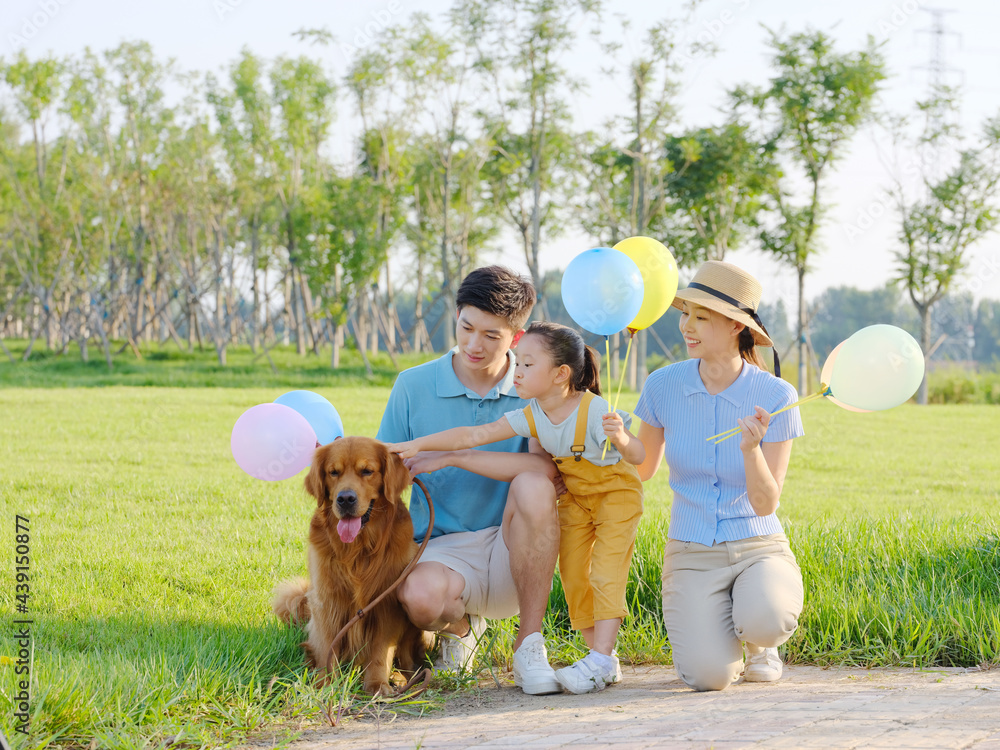 Happy family of three and pet dog in the park