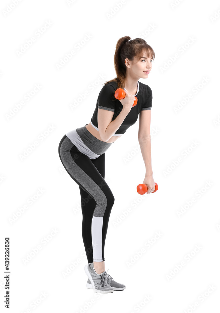 Sporty young woman training with dumbbells on white background