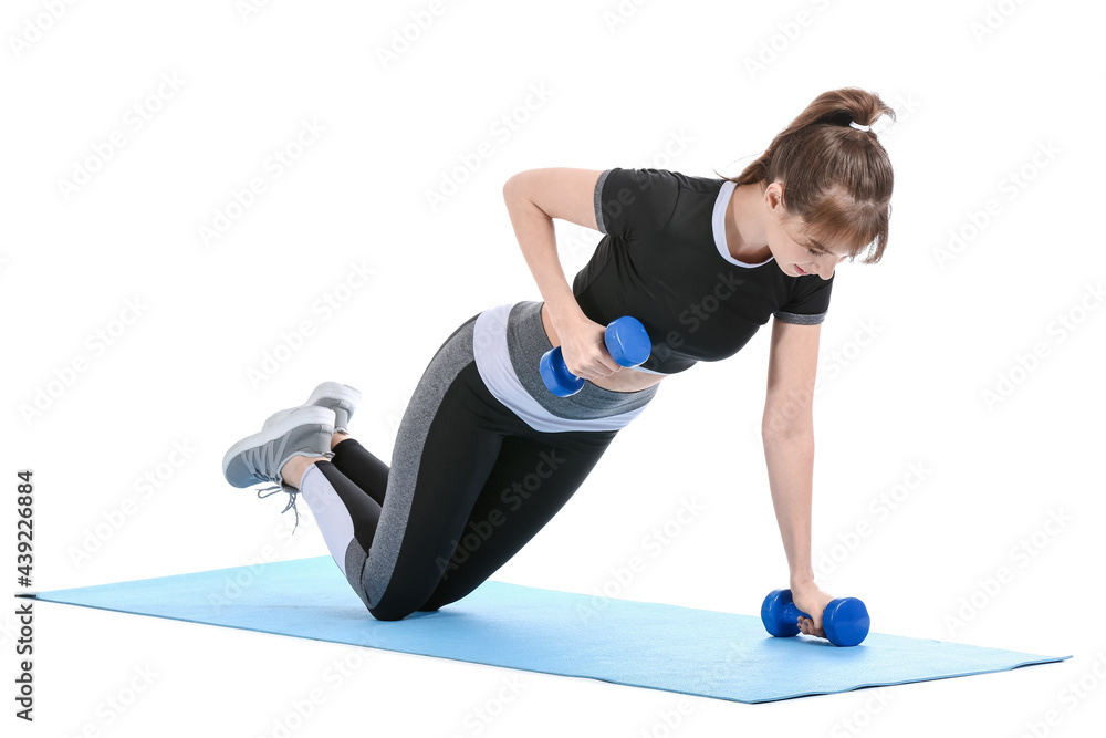 Sporty young woman training with dumbbells on white background