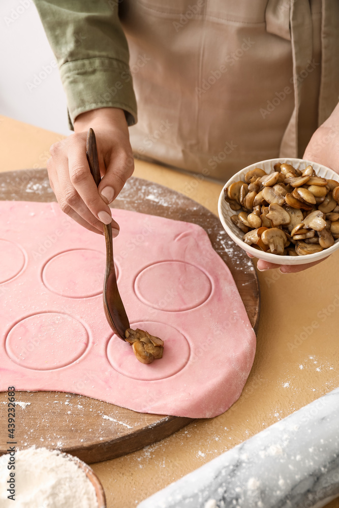 Female chef making delicious ravioli at table, closeup