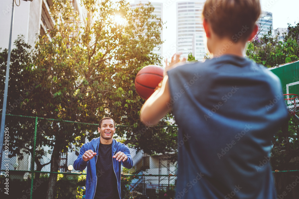 Young boy playing basketball with dad