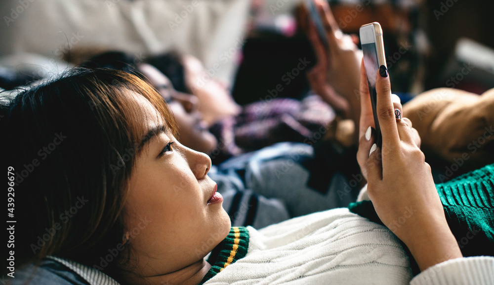 青少年女孩在床上使用智能手机参加睡眠派对