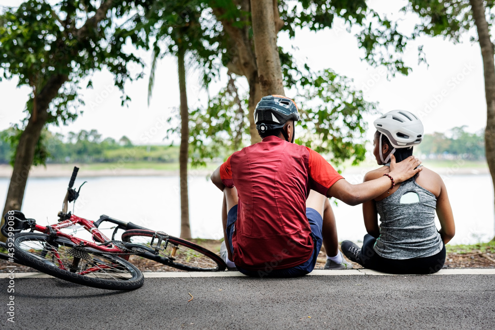 Cyclist couple resting in a park