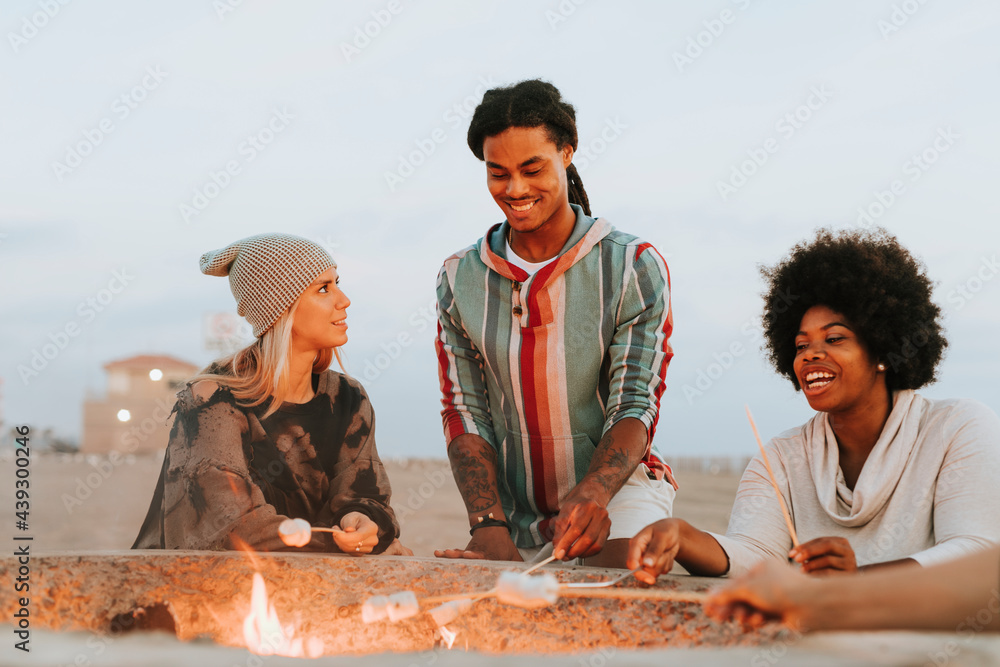 Friends roasting marshmallows at the beach