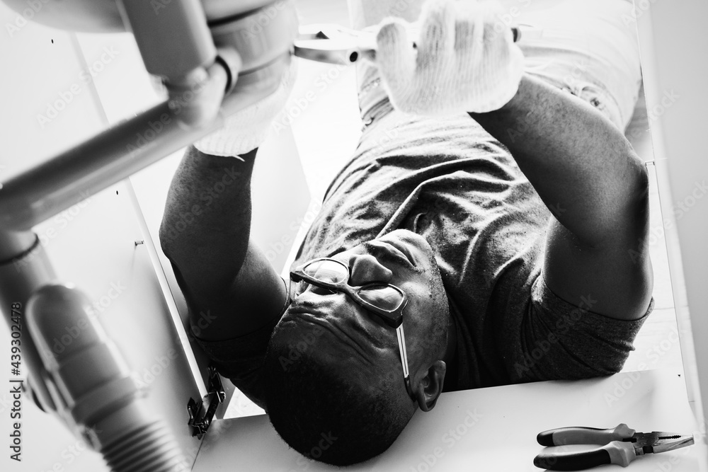 Plumber man fixing kitchen sink