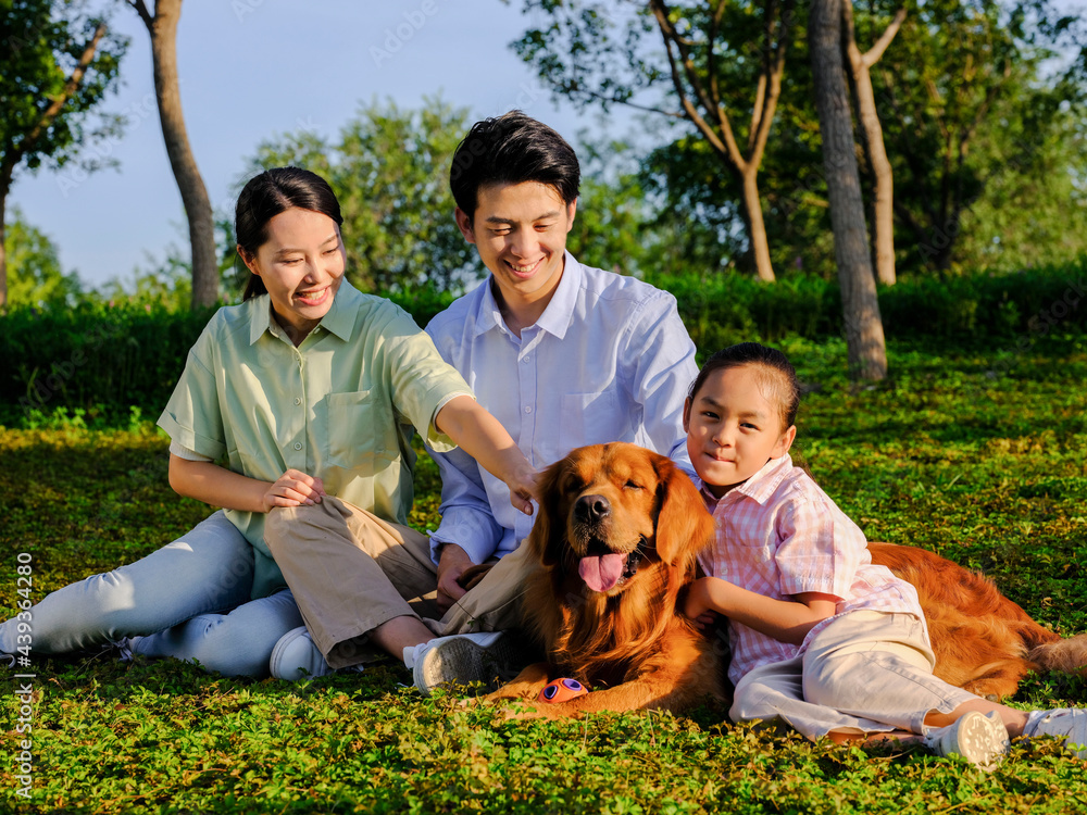 Happy family of three and pet dog in the park