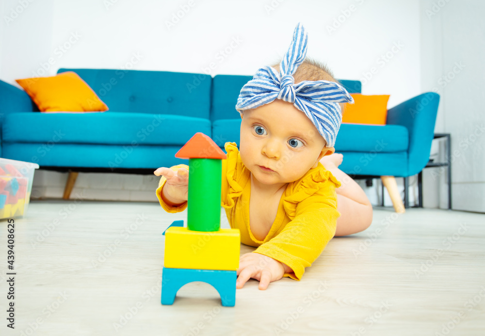 Little girl play with wooden blocks in living room