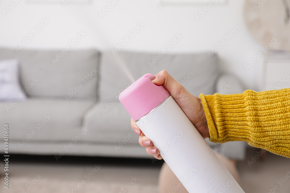 Young woman with air freshener at home, closeup