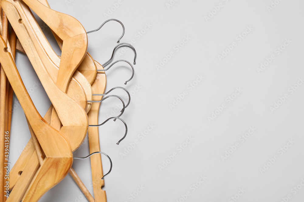 Stylish clothes hangers on light background