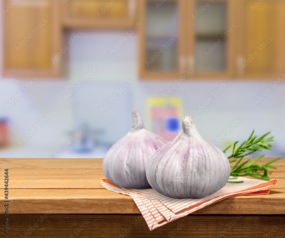 Heads of garlic, greens leaves and pepper for cooking.