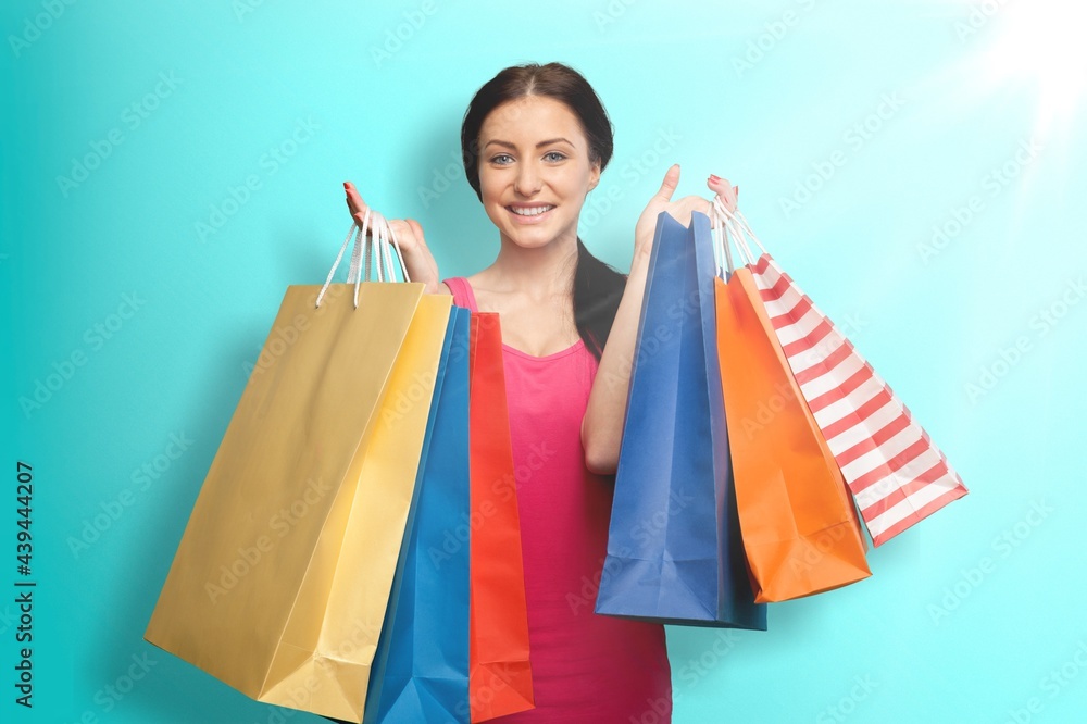 Photo of impressed young girl hold shopping bags on color background