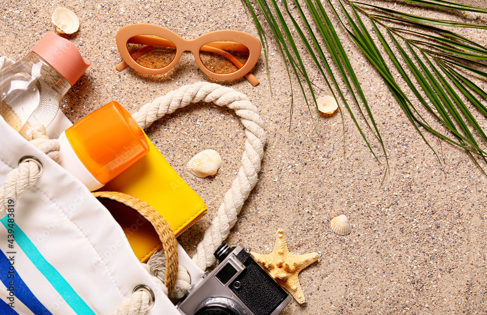 Bag with beach accessories on sand