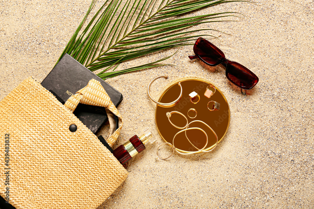 Stylish female accessories on sand