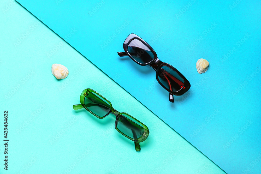 Stylish sunglasses on color background