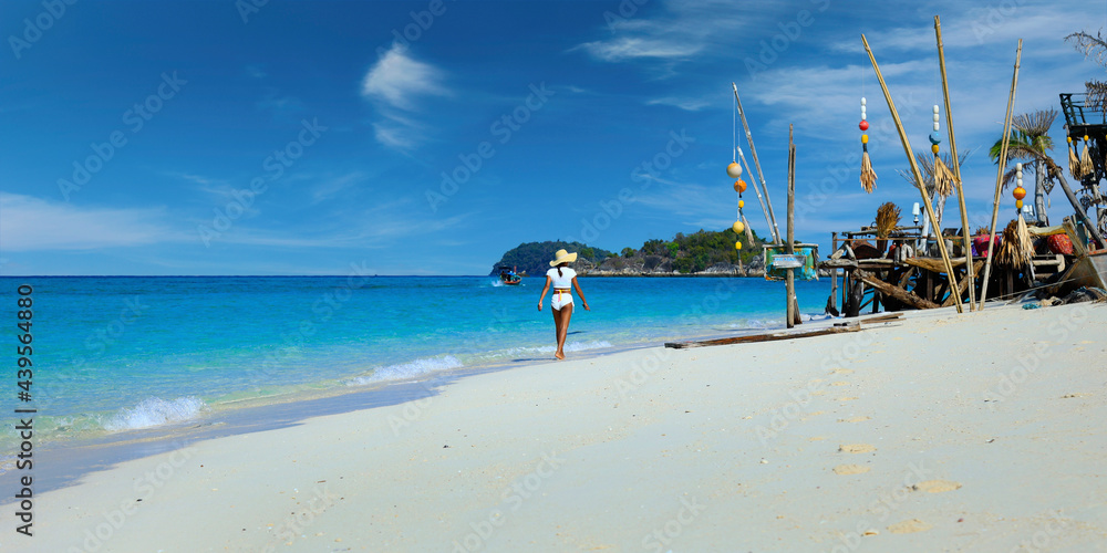 woman walking on white sand beach in the  andaman sea 