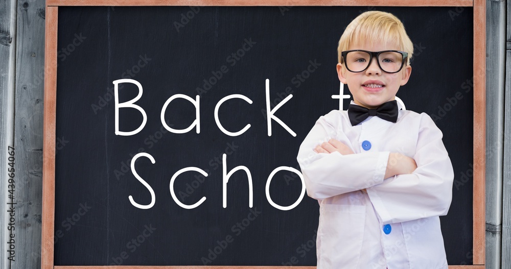 Composition of smiling schoolboy over white text back to school on chalkboard