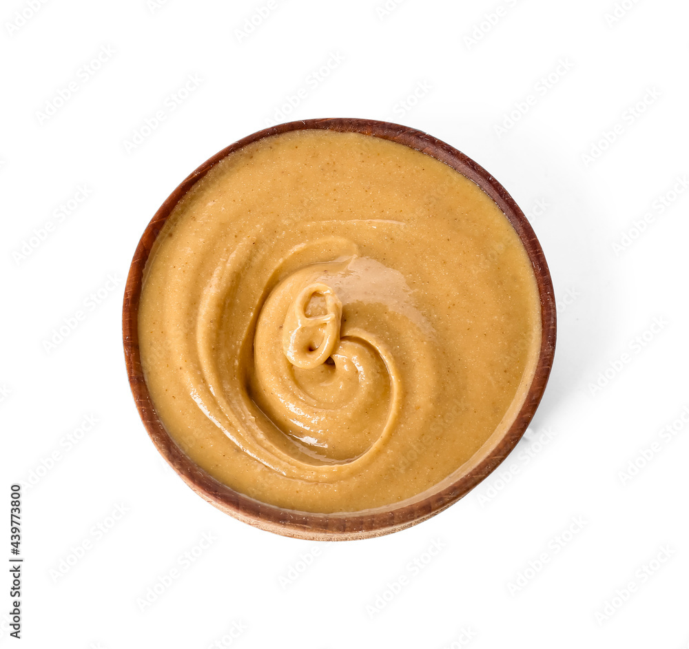 Bowl with tasty peanut butter on white background