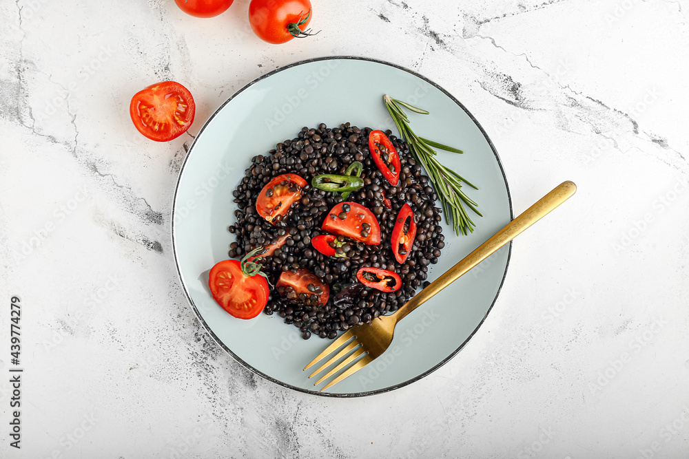 Plate with tasty cooked lentils and vegetables on white background