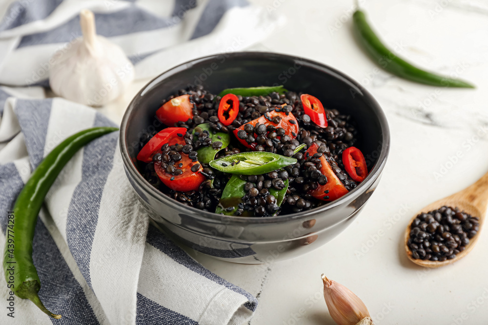 Bowl with tasty cooked lentils and vegetables on white background