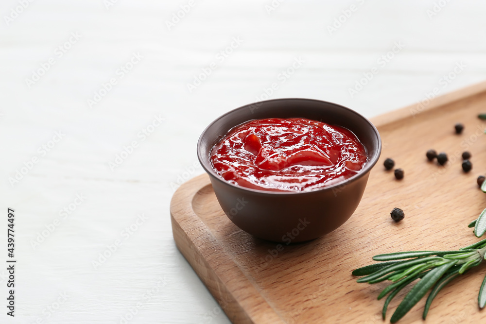 Bowl with tasty barbecue sauce on light wooden background