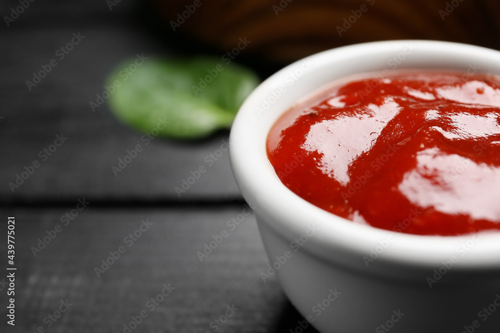 Bowl with tasty barbecue sauce on dark wooden background