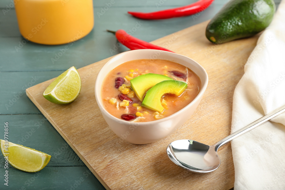 Bowl of tasty chicken enchilada soup on table